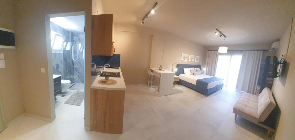One-bedroom apartment interior with bed, kitchen and seating