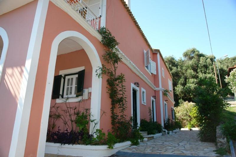 The coral-toned main building of Stavroula Studios with its garden
